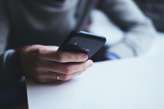 Teacher connecting mobile phone to school telephone system